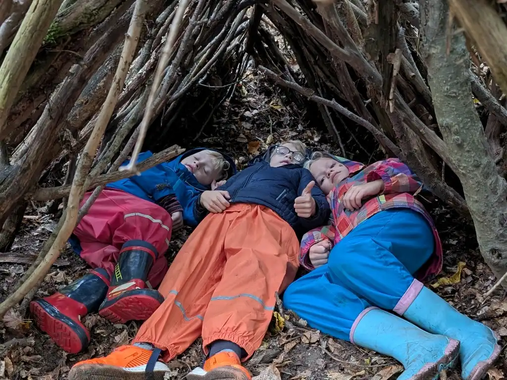 Kinder entspannen in der selbstgebauten Hütte beim Familientag