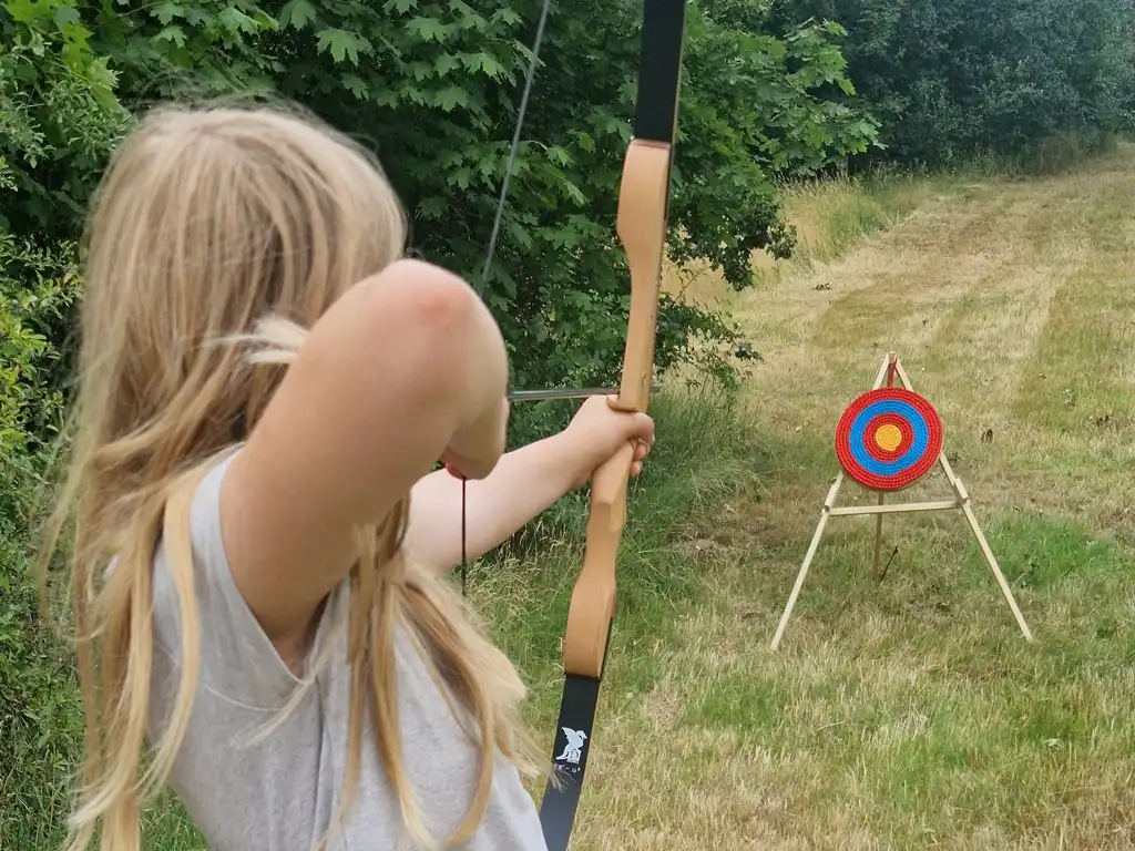 Ein Mädchen schießt mit dem Bogen beim wilden Projekttag an ihrer Schule.